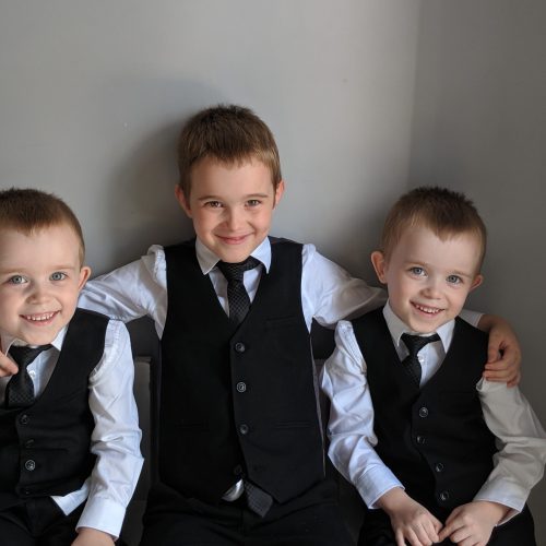 retrato-de-hermanos-sonrientes-con-trajes-contra-la-pared-en-casa